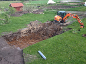 På bilden sysn grävning inför bygget av en Tjällden pool. Här används en mindre grävmaskin pga en mindre pool
